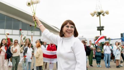 Belarusian opposition activist Olga Kovalkova waves with flowers during a protest rally in Minsk, Belarus, Saturday, Aug. 22, 2020. Police in Belarus have detained several leading opposition activists who helped spearhead a wave of protests demanding the resignation of authoritarian President Alexander Lukashenko. The Coordination Council established by the opposition to negotiate a transfer of power said Monday Aug. 24, 2020, police detained members Sergei Dylevsky and Olga Kovalkova in the capital of Minsk. (AP Photo/Evgeniy Maloletka, File)