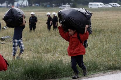 Un niño refugiado lleva sus pertenencias durante una operación policial en un campamento de refugiados en la frontera entre Grecia y Macedonia, cerca de Idomeni.