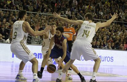 Navarro trata de abrirse paso entre los jugadores del Real Madrid, Reyes y Velickovic, durante el partido de la final de la 76ª Copa del Rey de Baloncesto, en el Palau Sant Jordi de Barcelona, el pasado febrero.