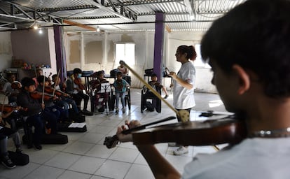 Agustina Llopis , frente a sus alumnos en un aula a medio terminar y de techo de chapa.