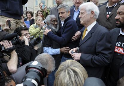 El actor George Clooney y su padre, el profesor universitario Nick Clooney, se dirigen a los medios de comunicación durante la manifestación frente a la embajada de Sudán en Washington, poco antes de ser arrestados por la policía.