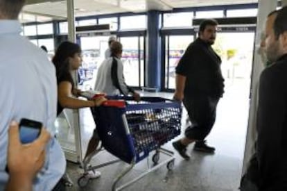 Fotografía facilitada por el SAT. Jornaleros sacan de un centro comercial diez carros llenos de material escolar.