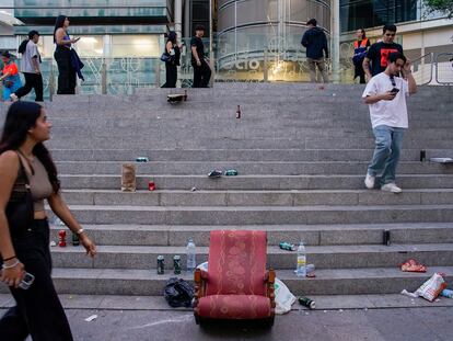 Una joven pasa delante de un sillón en medio de la basura antes del comienzo del concierto del reguetonero puertorriqueño Eladio Carrión en el WiZink Center, el viernes.