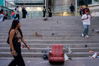 Una joven pasa delante de un sillón en medio de la basura antes del comienzo del concierto del reguetonero puertorriqueño Eladio Carrión en el WiZink Center, el viernes.