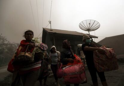 Cerca de 20.000 personas han tenido que ser evacuadas desde hace varios meses en las áreas en torno al Monte Sinabung, que ha entrado en erupción más de 50 veces desde el sábado pasado. En la imagen, evacuados sujetan sus pertenencias en el distrito Karo Payung, en la isla de Sumatra (Indonesia).