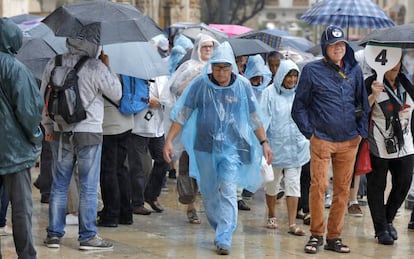 Personas se protegen de la lluvia que está cayendo en la ciudad de Valencia.