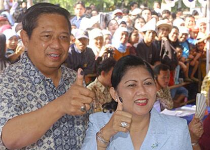 El general Yudhoyono y su esposa, Kristiani, muestran sus pulgares manchados tras votar en Yakarta.