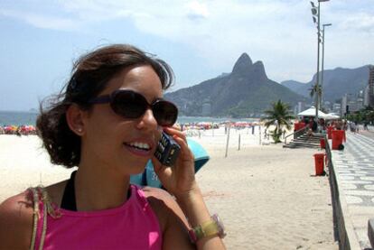 Una mujer habla por teléfono  en la playa de Ipanema, en Río de Janeiro.