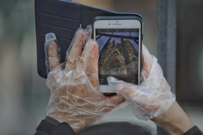 Todavía quedan turistas en Barcelona, convenientemente protegidos. Aunque no puedan entrar en el templo, no se irán sin la foto de la Sagrada Família.