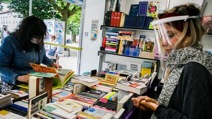 Una mujer mira un libro en la Feria del libro de 2020 de Santiago de Compostela.