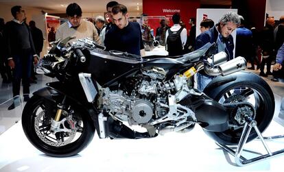 Varios visitantes al salón Eicma observa la nueva Ducati 1199
