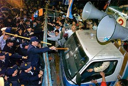 La policía de Taiwan cierra el paso a manifestantes de la oposición ante la sede de una junta electoral.