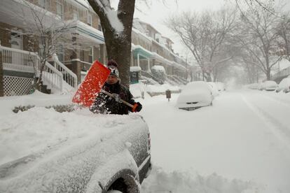 Un hombre limpia la nieve que tapa su vehículo en Parkview, Washington.