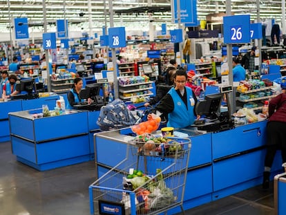 Cashiers process purchases at a Walmart Supercenter in North Bergen, N.J., on Feb. 9, 2023.