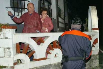 Un ertzaina dialoga con los habitantes de una vivienda próxima al edificio de Correos en donde explotó la bomba.