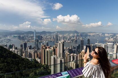 Una turista se refresca con un abanico en el Pico Vitoria, el punto más alto de Hong Kong. La ciudad asiática ha sido declarada la urbe más cara del mundo para expatriados, según el último estudio de la firma Mercer.