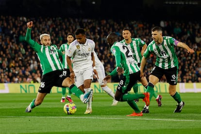 Rodrygo trata de internarse en el área del Betis ante la presión de varios jugadores verdiblancos.