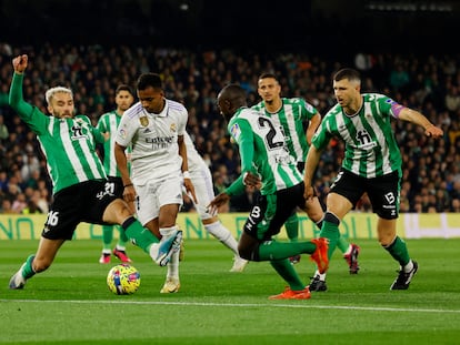 Rodrygo trata de internarse en el área del Betis ante la presión de varios jugadores verdiblancos.