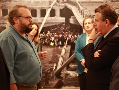 El periodista Luis de Vega conversa con el presidente de la Diputación de Sevilla, Javier Fernández, en la inauguración de su exposición sobre la guerra en Ucrania.