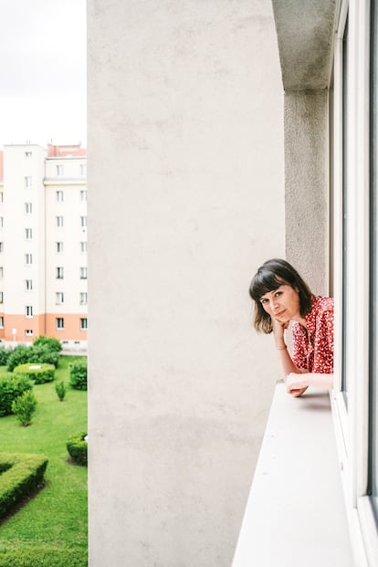 Barbara Schubert se asoma a la ventana de su casa en Viena, una vivienda subsidiada por el Ayuntamiento.