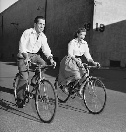Lauren Bacall. La actriz estadounidense Lauren Bacall y su marido, el actor Humphrey Bogart, montan en bicicleta durante el rodaje de la película Cayo Largo (John Huston, 1948). Ella combina su perfecta camisa blanca con una falda muy de la época y unas alpargatas.
