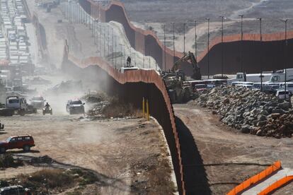 Una vista general muestra que las fuerzas de seguridad mexicanas (a la izquierda) vigilan la cerca fronteriza entre México y Estados Unidos, antes de la visita del presidente de los Estados Unidos.