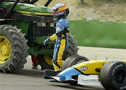 Fernando Alonso abandona su coche, averiado, tras salirse de la pista.