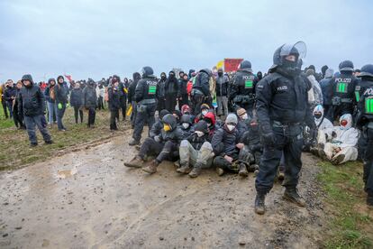 Agentes de las fuerzas de seguridad vigilan un grupo de manifestantes.