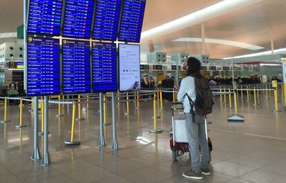 Un pasajero mira los paneles informativos hoy en la T-1 del aeropuerto de El Prat.