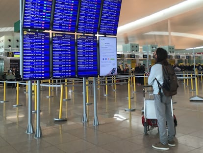 Un pasajero mira los paneles informativos hoy en la T-1 del aeropuerto de El Prat.