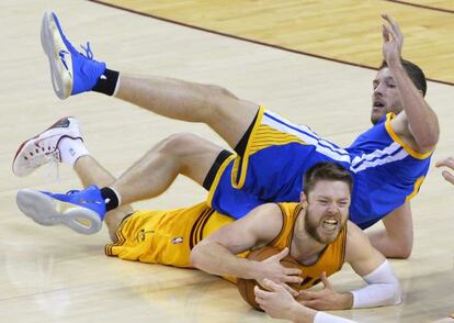 Dellavedova atrapa un bal&oacute;n en pugna con David Lee.