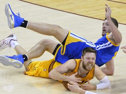 Dellavedova atrapa un bal&oacute;n en pugna con David Lee.