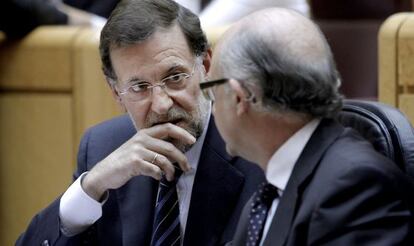 El presidente, Mariano Rajoy, conversa con el ministro de Hacienda, Cristóbal Montoro, en el Senado.