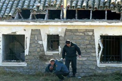 Miembros de la Guardia Civil inspeccionan el lugar en donde estalló la mochila en la casa cuartel de Luna.