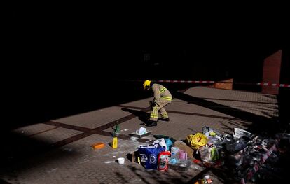 Um bombeiro remove coquetéis molotov do interior da Universidade Politécnica, nesta quinta-feira.