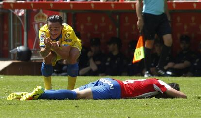 MIkel Vesga, en el suelo, y Roque Mesa, en cuclillas, durante el partido entre Sporting y Las Palmas del fin de semana pasado.