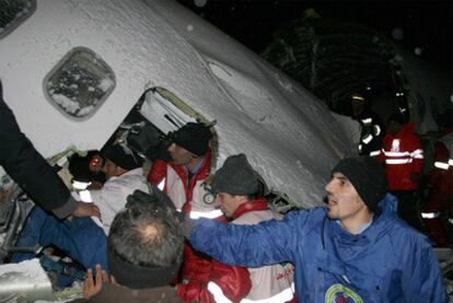 Equipos de rescata trabajan alrededor de los restos del avión accidentado.