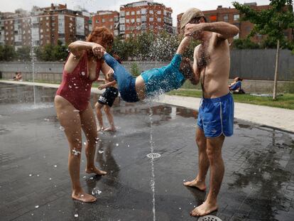 MADRID, 12/06/2022.- Una familia juega en la fuente de un parque en Madrid este domingo. El calor sigue azotando a gran parte de España, una situación que, según todos los pronósticos, se mantendrá durante varios días, con temperaturas muy elevadas para esta época del año que obligan a extremar las precauciones. EFE/ Mariscal
