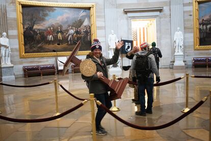 One of the assailants, with a lectern for then-Speaker of the House Nancy Pelosi, on Capitol Hill, on January 6, 2021.