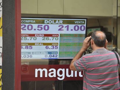Un hombre observa una pizarra con la cotización del dólar en una casa de cambio en Buenos Aires.