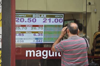 Un hombre observa una pizarra con la cotización del dólar en una casa de cambio en Buenos Aires.