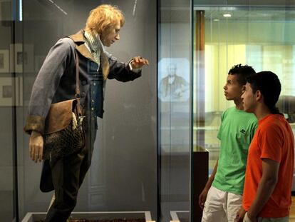 Dos jóvenes observan una reproducción de Charles Darwin en la exposición <i>La evolución de Darwin </i>del Museo Nacional de Ciencias Naturales.