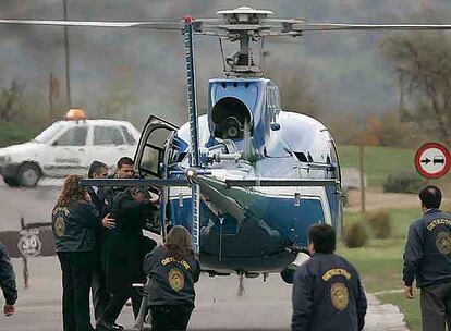 Agentes de la policía chilena ayudan a Alberto Fujimori a subir al helicóptero que lo condujo ayer al aeropuerto de Santiago.