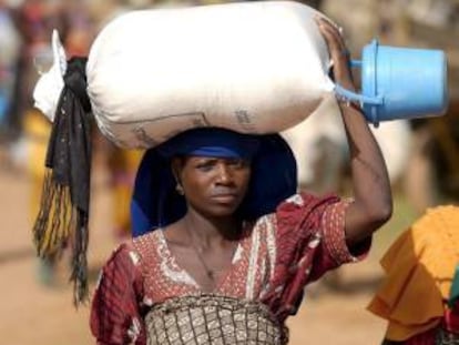 Una mujer lleva un saco de cereal fuera del centro terapéutico de alimentación de la organización humanitaria 'Medecins Sans Frontieres' (MSF) en Africa. EFE/Archivo