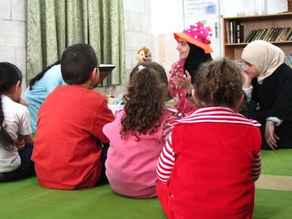 Rana Dajani, con sombrero, lee un cuento a varios niños en Amán.