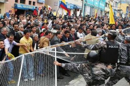 Cientos de manifestantes se enfrentan el martes a la policía, frente a la sede del Parlamento en Quito.