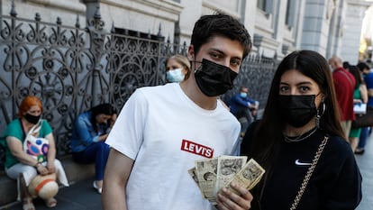 Mario Rodríguez, de 18 años, junto a su hermana Alba, de 23, esperan para cambiar las pesetas de su abuela en el Banco de España.