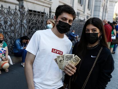 Mario Rodríguez, de 18 años, junto a su hermana Alba, de 23, esperan para cambiar las pesetas de su abuela en el banco de España.