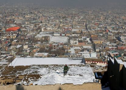 Un niño limpia la nieve del tejado de su casa en Kabul (Afganistán). 