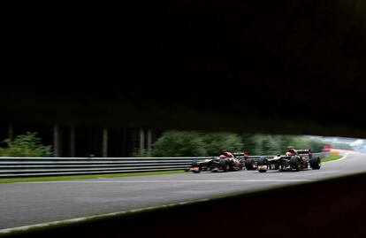 Los monoplazas de Daniel Ricciardo (Toro Rosso) y Romain Grosjean (Lotus), vistos a través del guardarraíl.